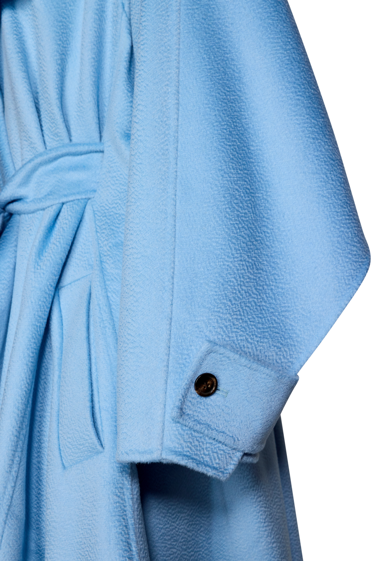 Close-up of a light blue textured coat or robe with a matching tie belt and a single dark button on the sleeve cuff.